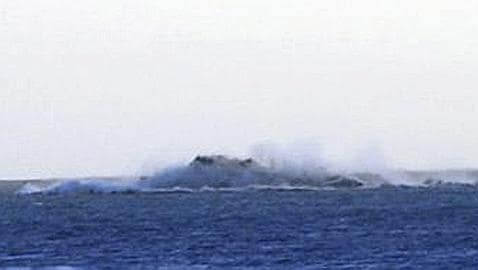 Imagen de una columna de vapor con ceniza en el mar
