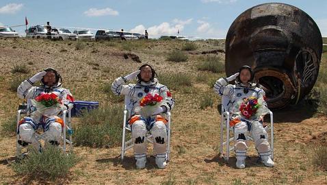 Los tres astronautas chinos y la cápsula tras su aterrizaje en una pradera de Mongolia Interior 