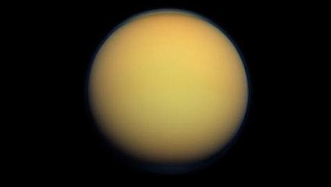 Titán, envuelta por una gruesa capa de atmósfera naranja