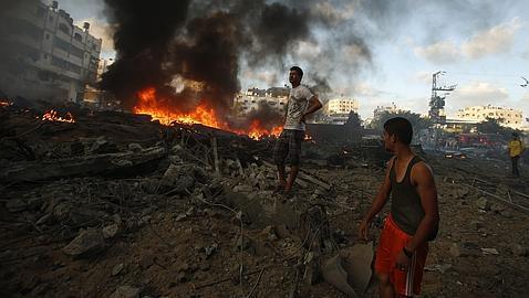 Testigos miran el fuego tras un bombardeo en Gaza