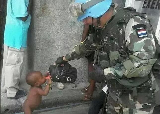 La foto de un soldado que da de beber a un niño haitiano conmociona la Red