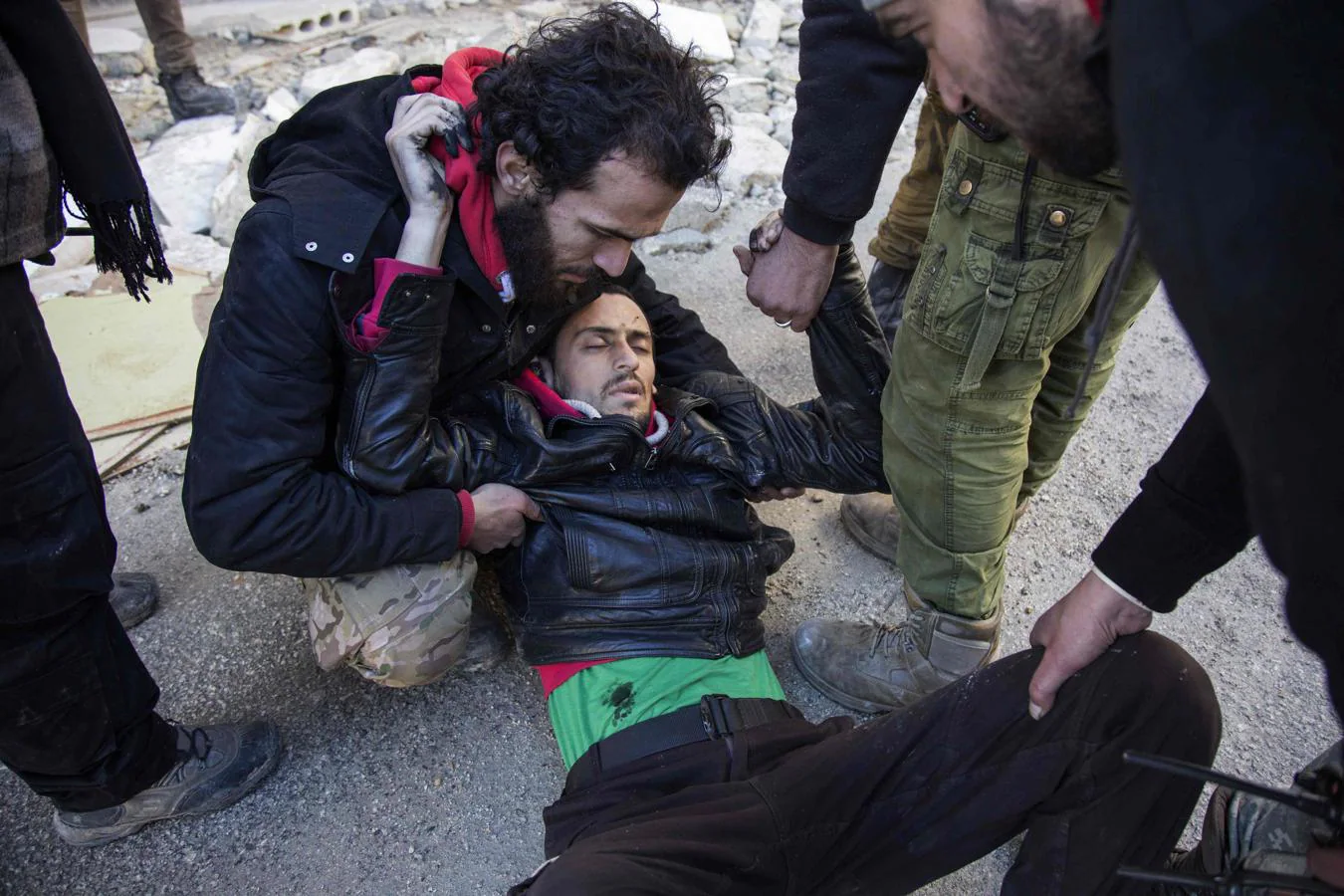 Un hombre herido recibe ayuda mientras los rebeldes sirios y sus familias abandonan el este de Alepo