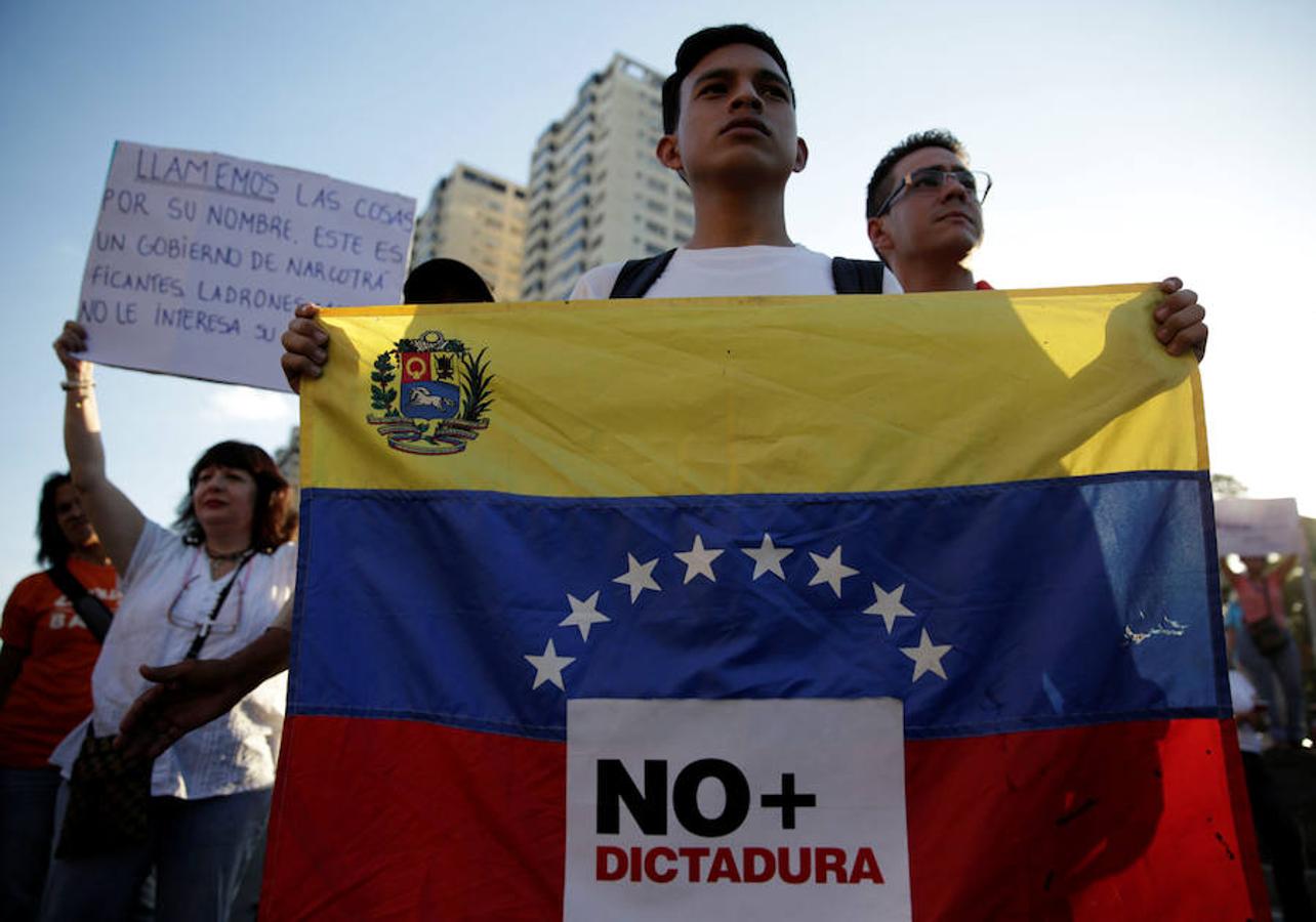 Un estudiante porta una bandera en la que se puede leer «no más dictadura» en una de las protestas organizadas en Caracas