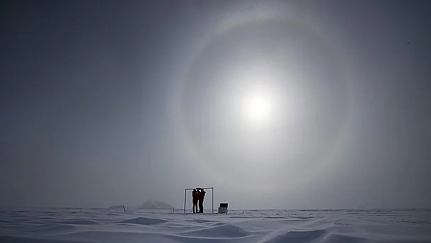 Imagen tomada el 18 de noviembre de 2015 que muestra a dos científicos midiendo la radiación solar y su albedo en el campamento Glaciar Union