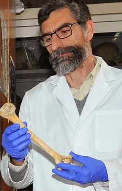 Antonio Rosas sostiene un fémur de neandertal