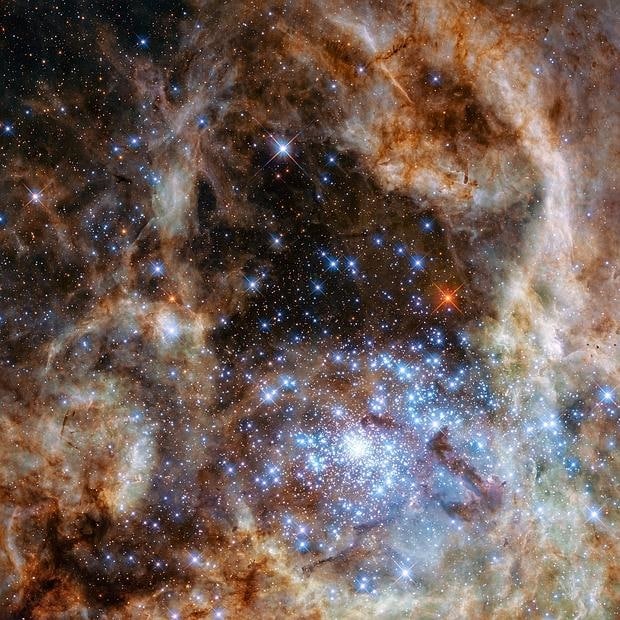La región central de la nebulosa de la Tarántula en la Gran Nube de Magallanes. El cúmulo de estrellas R136 joven y denso se puede ver en la parte inferior derecha de la imagen