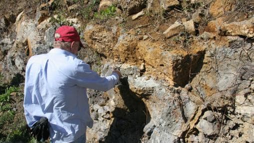 El investigador Lewis Ashwal recoge muestras de las rocas de la isla