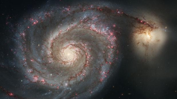La galaxia Remolino (a la izquierda) se está fundiendo con la pequeña galaxia NGC 5195