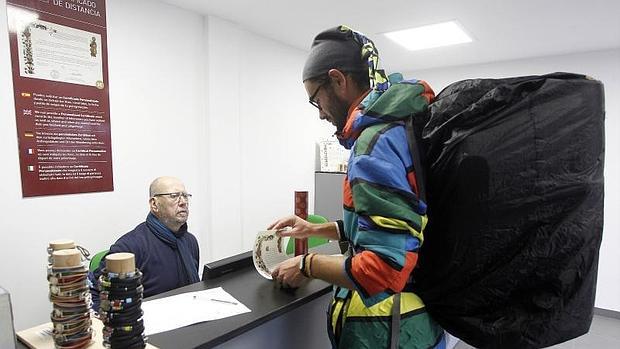 Un joven recoge su «compostela» en el nuevo Centro internacional de acogida al peregrino de Santiago