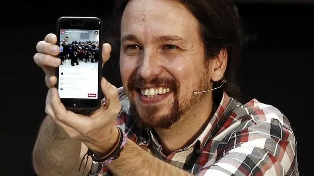 El secretario general de Podemos, Pablo Iglesias, con su móvil