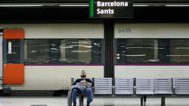 Un ciudadano espera en un banco de la estación de Sants de Barcelona