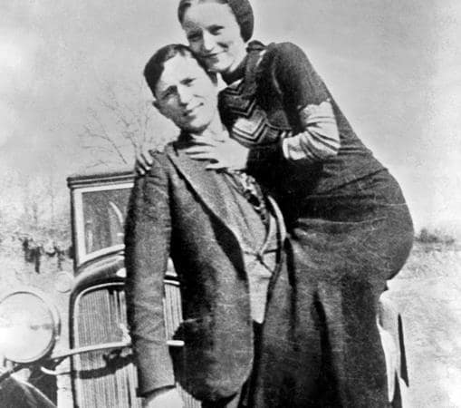 Bonnie en brazos de Clyde, delante de su Ford, como cualquier pareja de enamorados