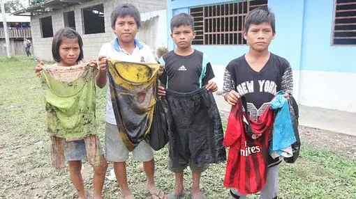Niños de Nazareth (Amazonas) muestran cómo quedó su ropa tras recoger petróleo