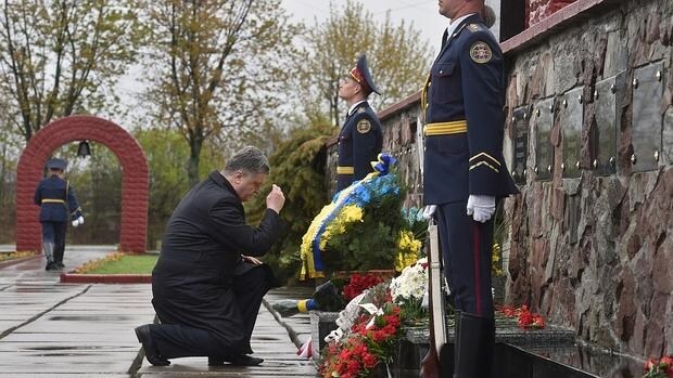 El presidente de Ucrania, Petro Poroshenko, se santigua tras colocar unas flores en el memorial levantado en recuerdo de las víctimas cerca de la central de Chernóbil