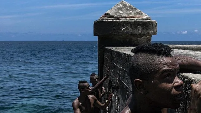 Unos jóvenes se disponen a zambullirse en el mar en Centro Habana