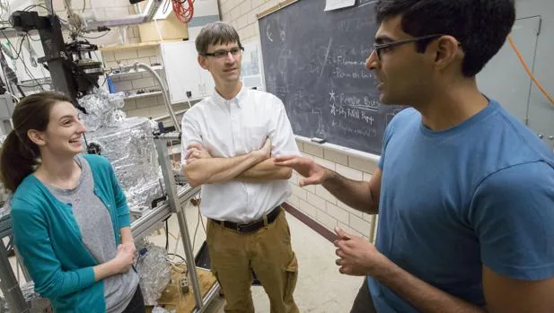 El profesor de Física Peter Abbamonte (centro) trabaja con estudiantes graduados en su laboratorio en la Universidad de Illinois