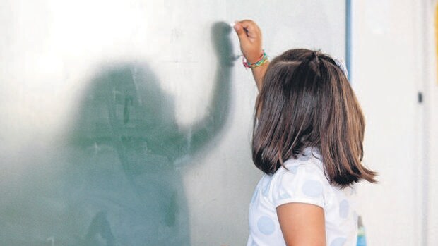 Imagen de archivo de una alumna escribiendo en la pizarra de un colegio