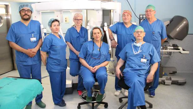 El equipo de cirugía que ha participado en la primera operación a un niño con el robot Da Vinci (al fondo), en el Hospital Clínico de Madrid