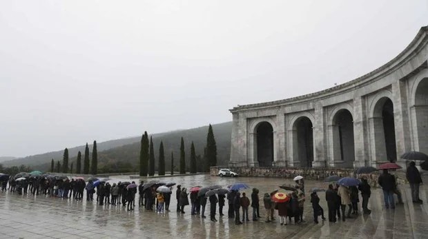 Una larga cola de visitantes aguarda a las puertas del Valle de los Caídos para entrar a la basílica pese a la lluvia