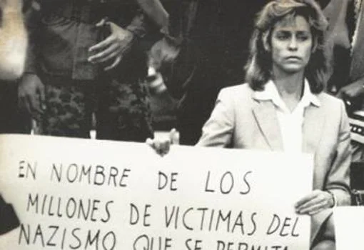 Beate, con una pancarta en castellano solicitando la extradición de Barbie en Latinoamérica