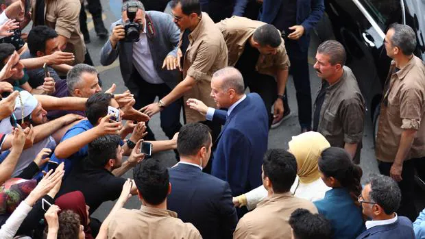 El presidente turco, Recep Tayyip Erdogan (C) saluda a sus partidarios cuando se va despuÃ©s de emitir su voto para las elecciones presidenciales y parlamentarias turcas en Estambul