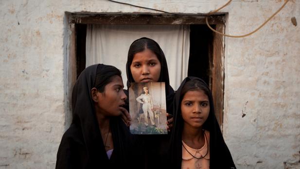 Las hijas de Asia Bibi posan con un retrato de su madre